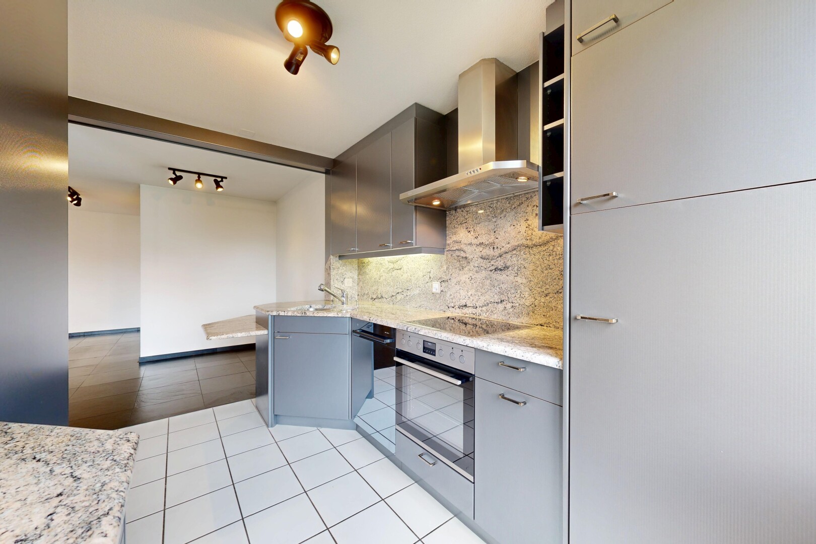 kitchen featuring decorative backsplash, light tile patterned floors, light stone counters, oven, and modern cabinets