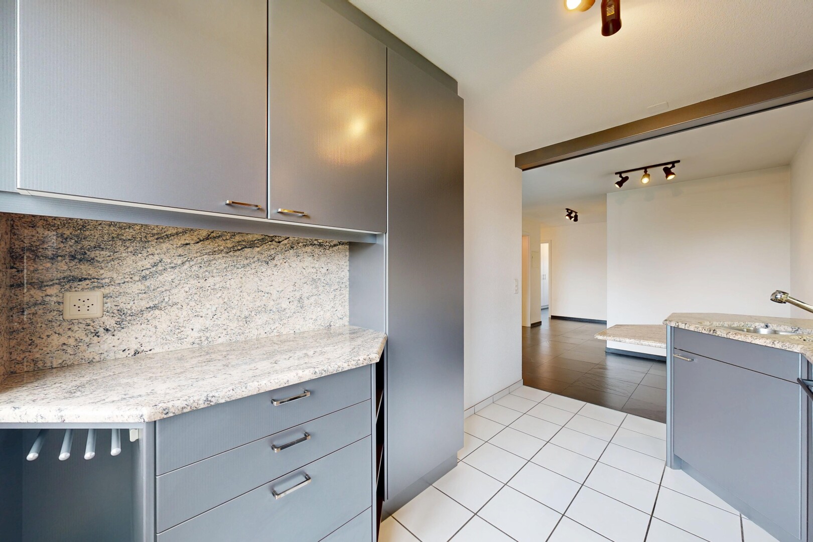 kitchen with gray cabinets, light tile patterned floors, light stone countertops, tasteful backsplash, and track lighting