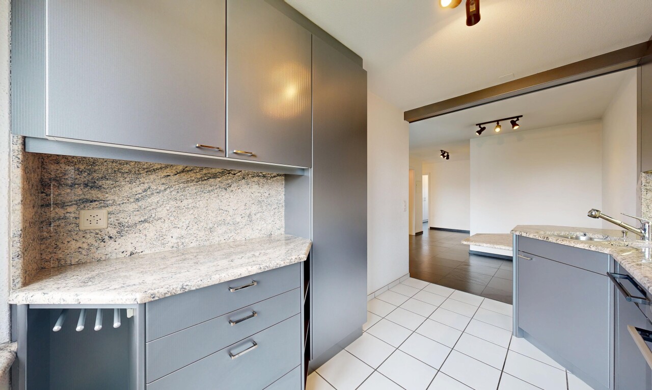kitchen with gray cabinets, light tile patterned floors, light stone countertops, tasteful backsplash, and track lighting
