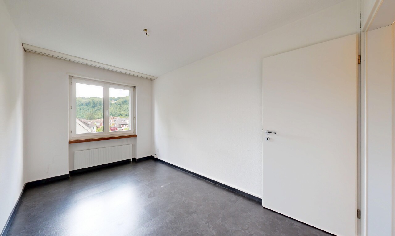 empty room featuring radiator heating unit and concrete floors