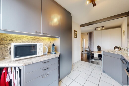 küche mit graue schränke, mikrowelle, stein arbeitsplatten, küchenrückwand beim herd, und küchenrückwand beim Herd