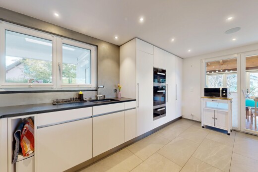 kitchen with dark countertops, black microwave, white cabinets, modern cabinets, and light tile patterned floors