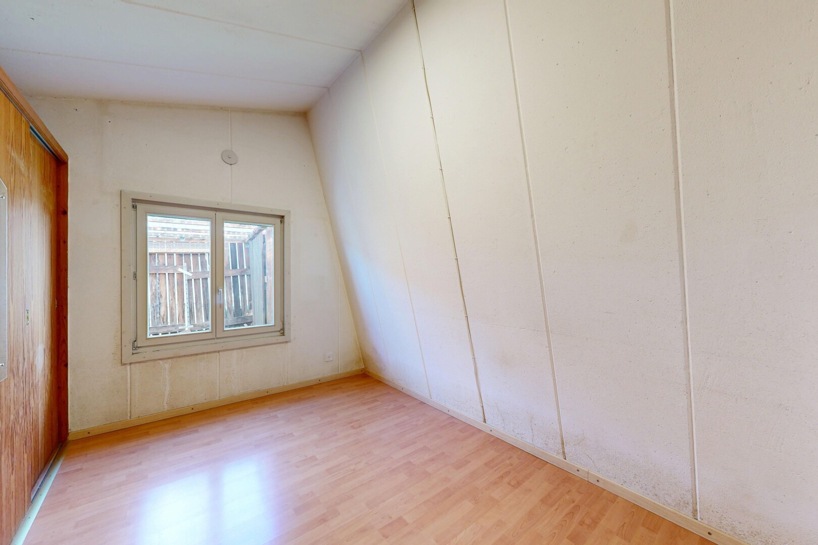 leerer raum mit vaulted ceiling, dachschräge, wood finish floor, holzfußboden, und natural light