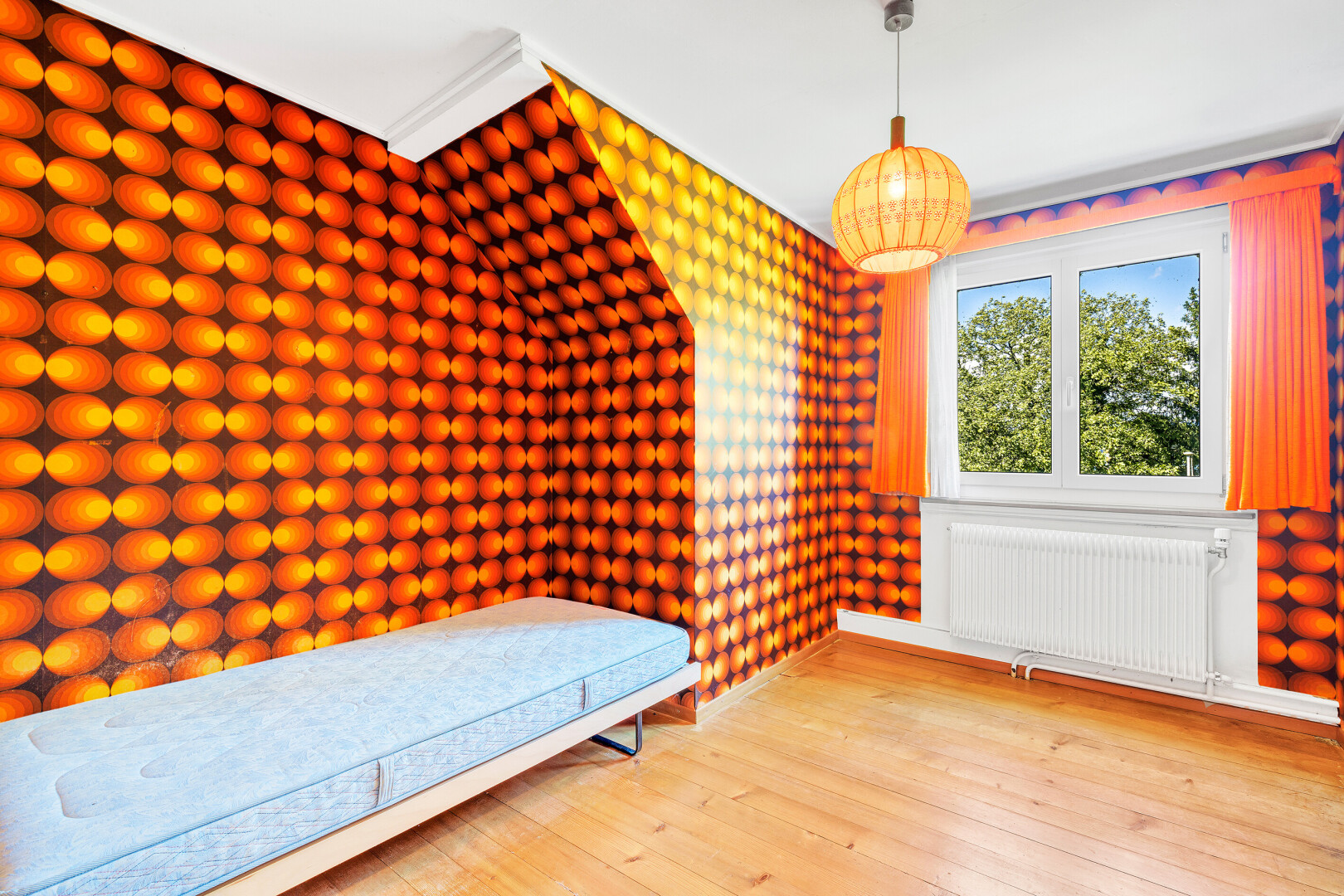 chambre avec radiateur, sol en finition bois, wood finish floor, inside property, et lumière naturelle