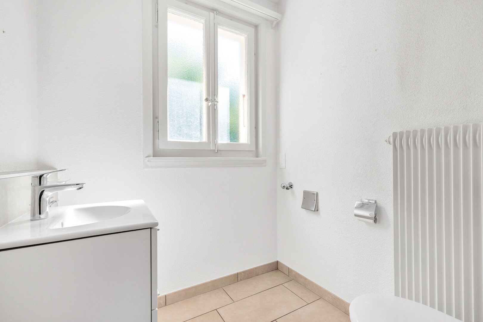 salle de bains avec inside property, natural light, lumière naturelle, lavabo (ou coiffeuse selon le contexte), et tile floor