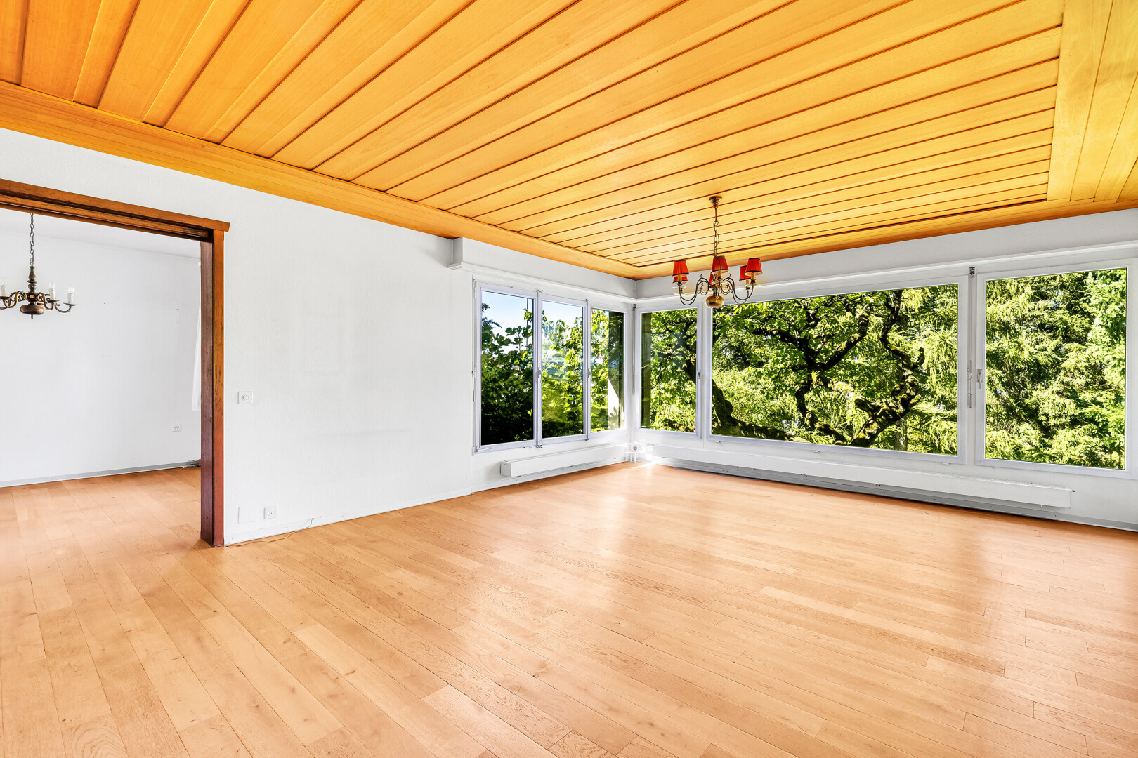 pièce vide avec lustre remarquable, wood ceiling, plafond en bois, inside property, et natural light