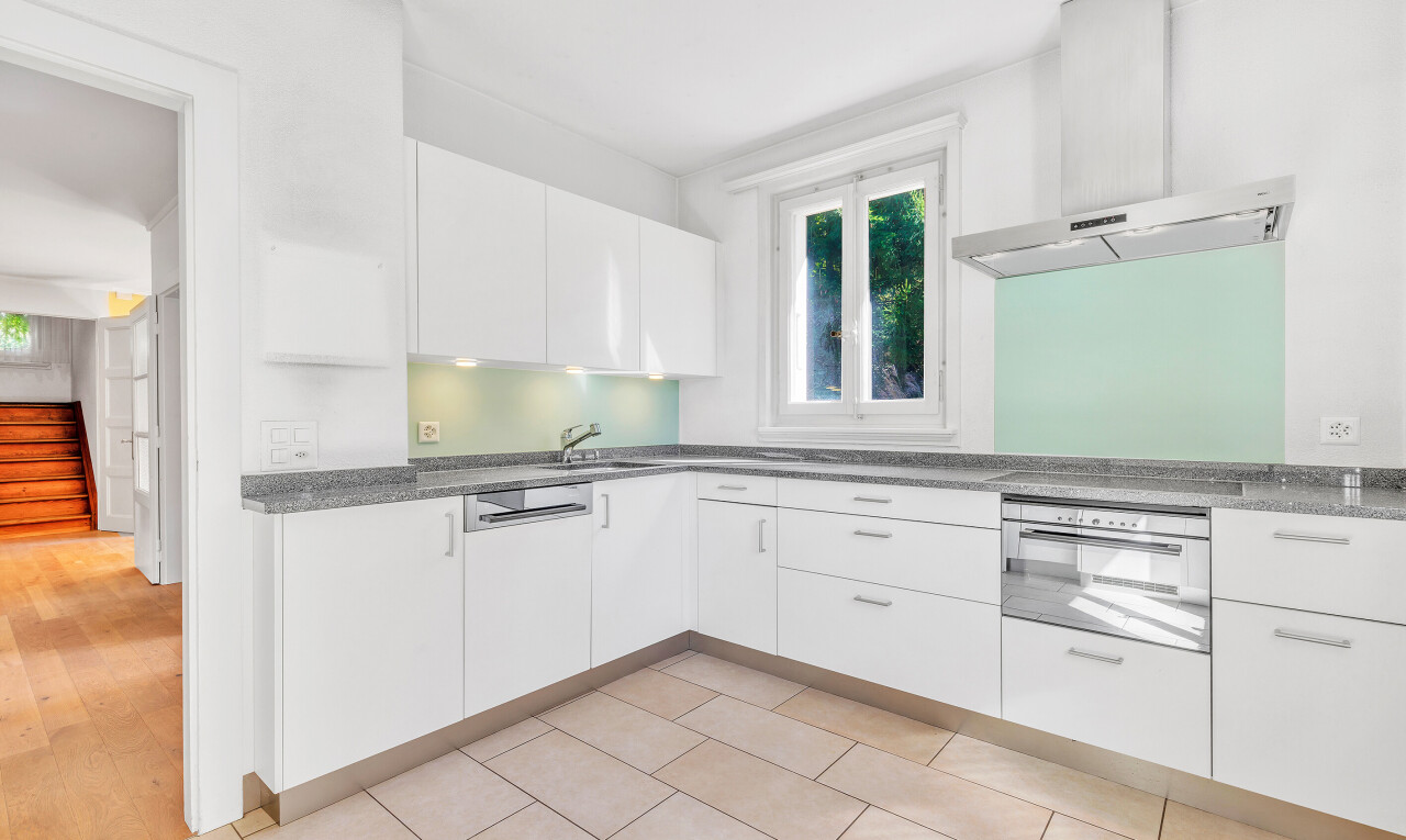 küche mit weiße schränke, dunstabzugshaube, natural light, natürliches licht, und stein arbeitsplatten