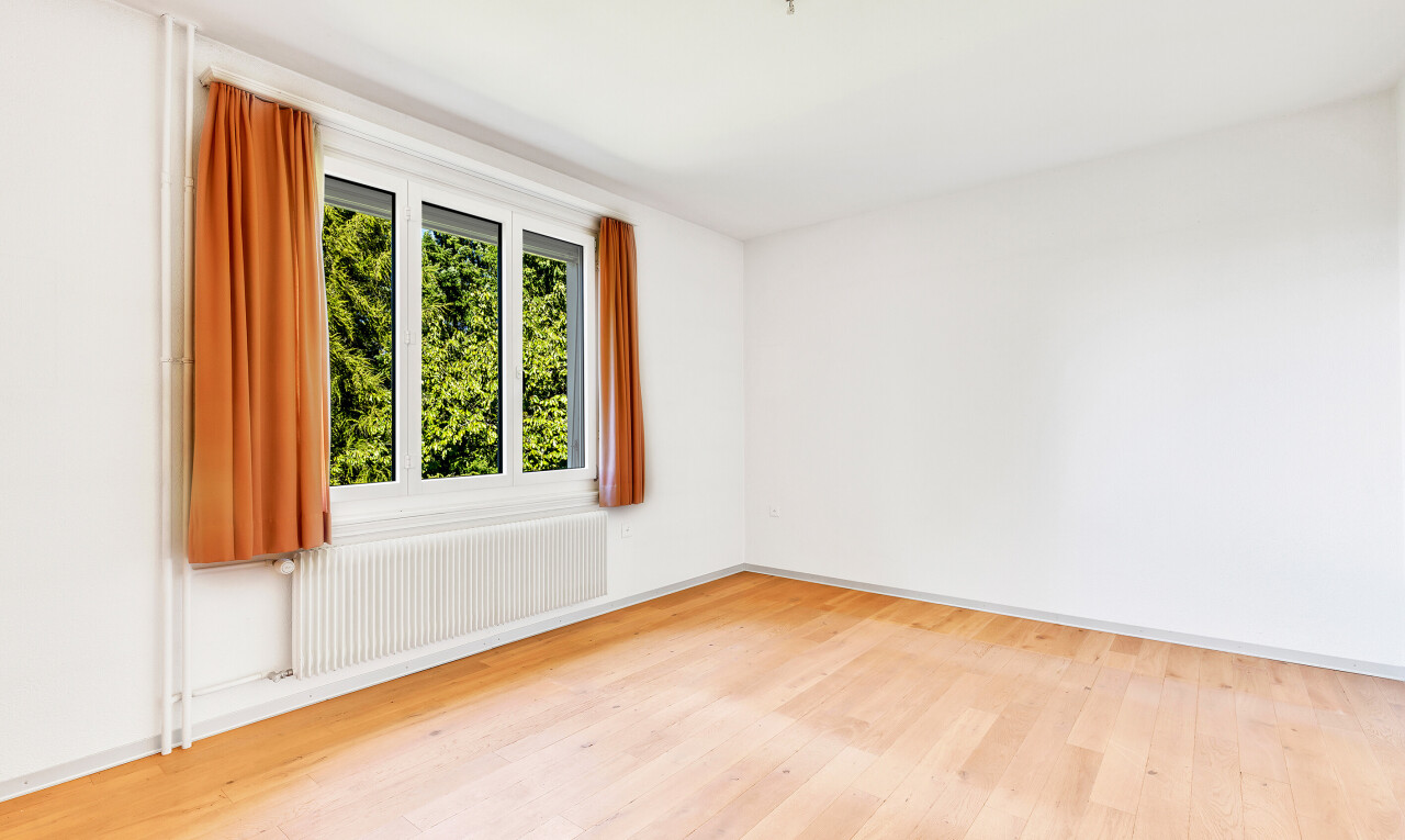 pièce vide avec radiateur, lumière naturelle, natural light, sol en finition bois, et wood finish floor