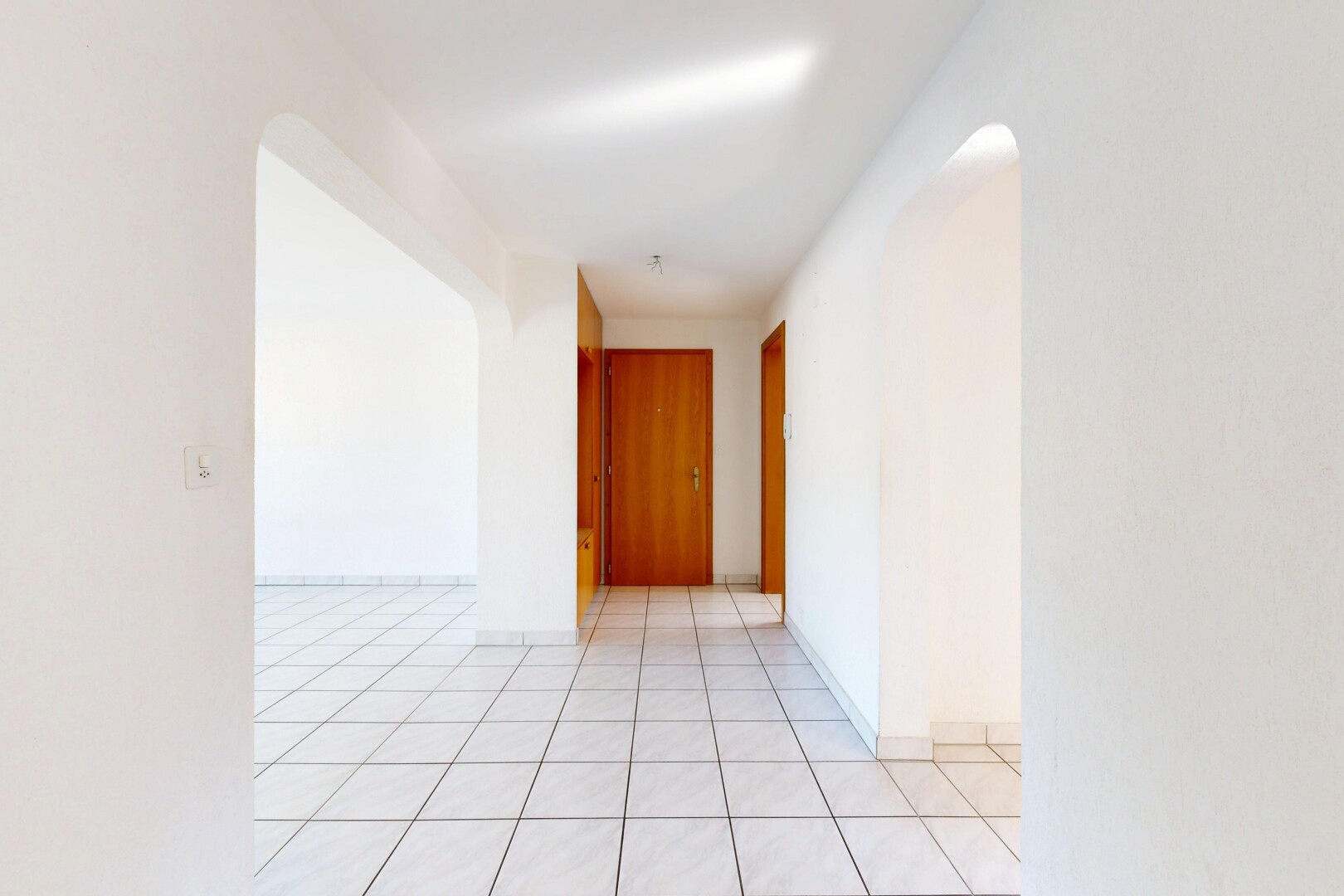 leerer raum mit gewölbte gehwege, gipskartonwand, drywall, light floor, und inside property