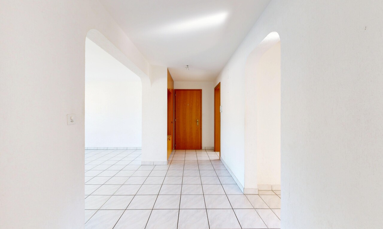 leerer raum mit gewölbte gehwege, gipskartonwand, drywall, light floor, und inside property