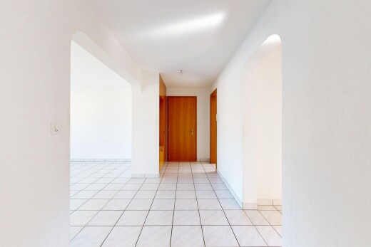 leerer raum mit gewölbte gehwege, gipskartonwand, drywall, light floor, und inside property