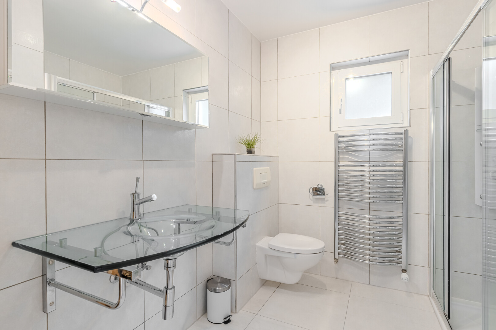salle de bains avec miroir, tile wall, mur en carrelage, salle de bain complète, et toilette
