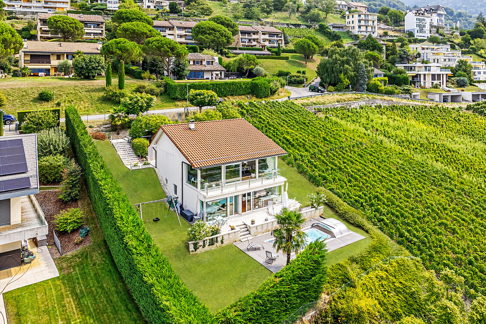 façade avec terrasse, clôture, pelouse, bain à remous, et orchard / agricultural view