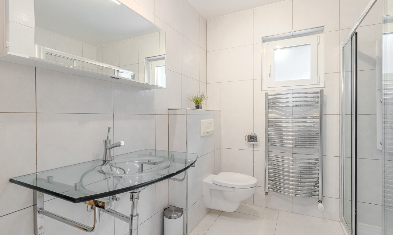 salle de bains avec miroir, tile wall, mur en carrelage, salle de bain complète, et toilette