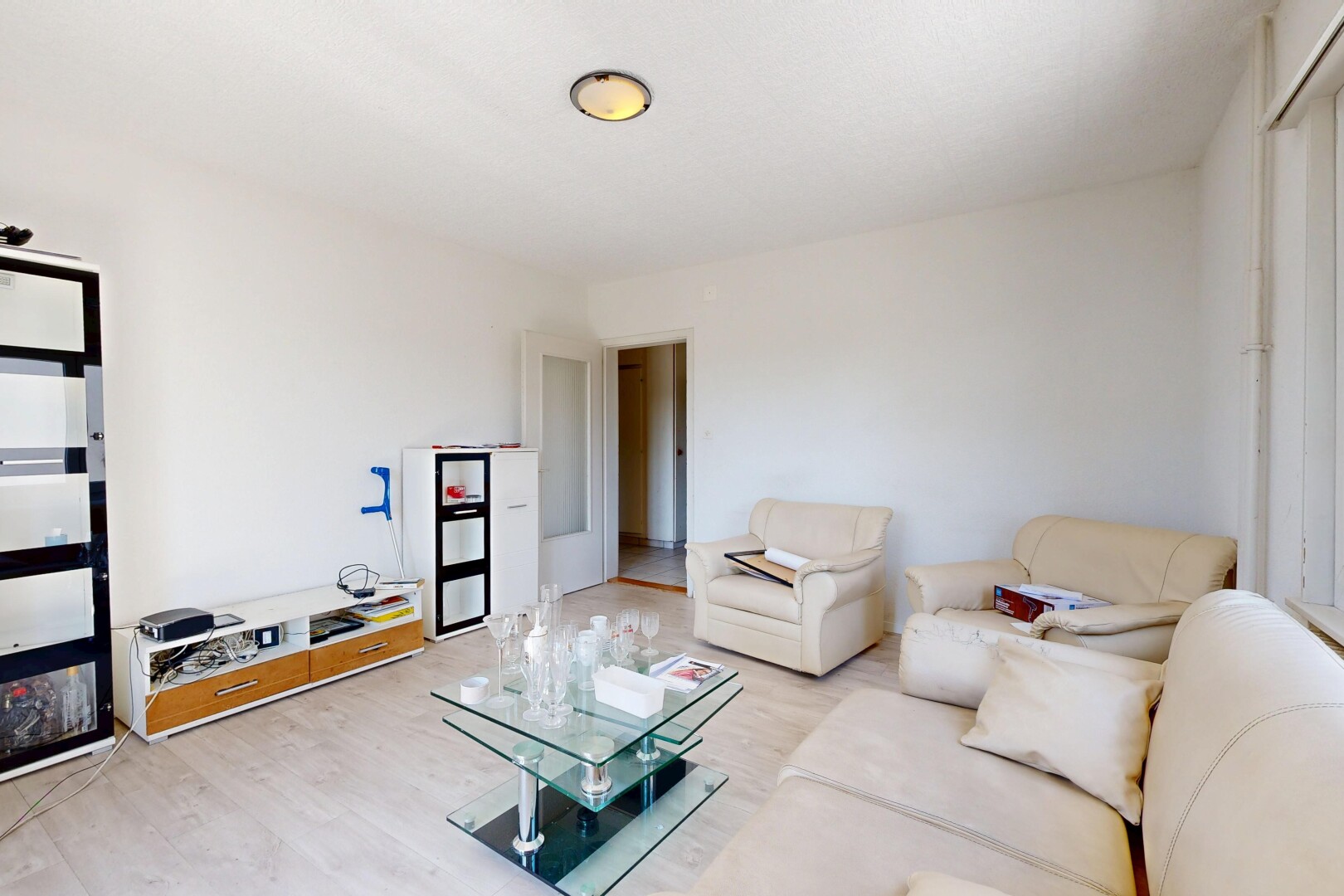 salon avec inside property, cloison sèche, drywall, sol en finition bois, et wood finish floor