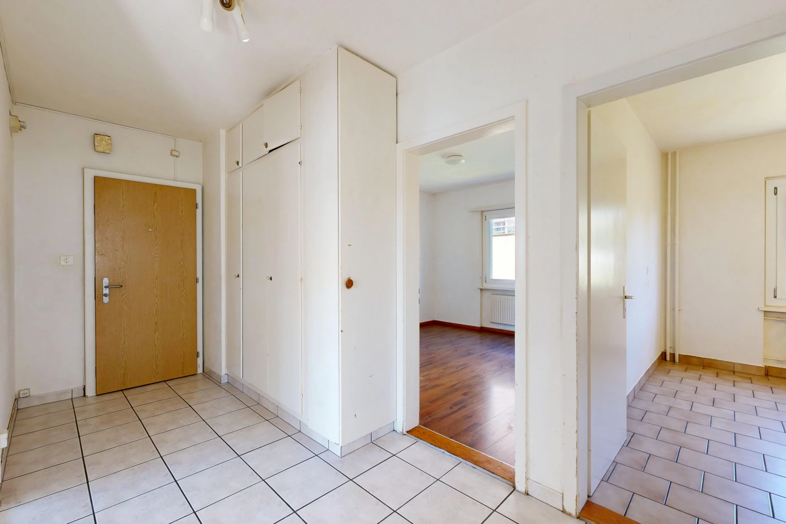 couloir avec light floor, drywall, cloison sèche, tile floor, et sol en carrelage