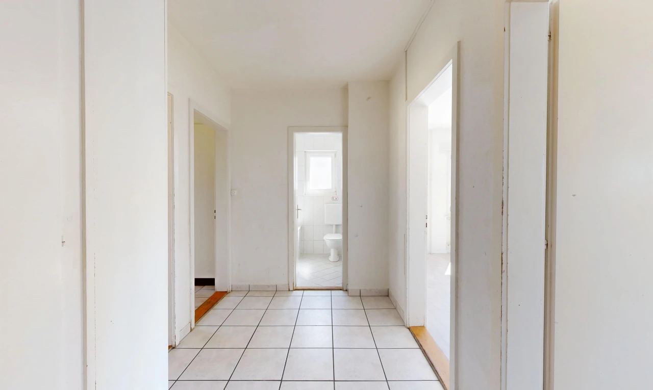 couloir avec light floor, tile floor, sol en carrelage, drywall, et cloison sèche