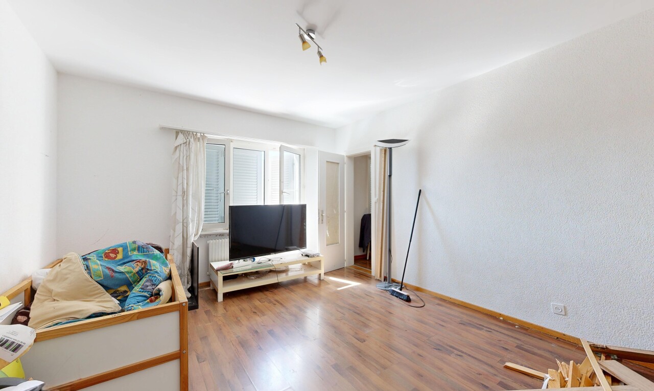 salon avec télévision, sol en finition bois, wood finish floor, éclairage sur rail, et track lighting