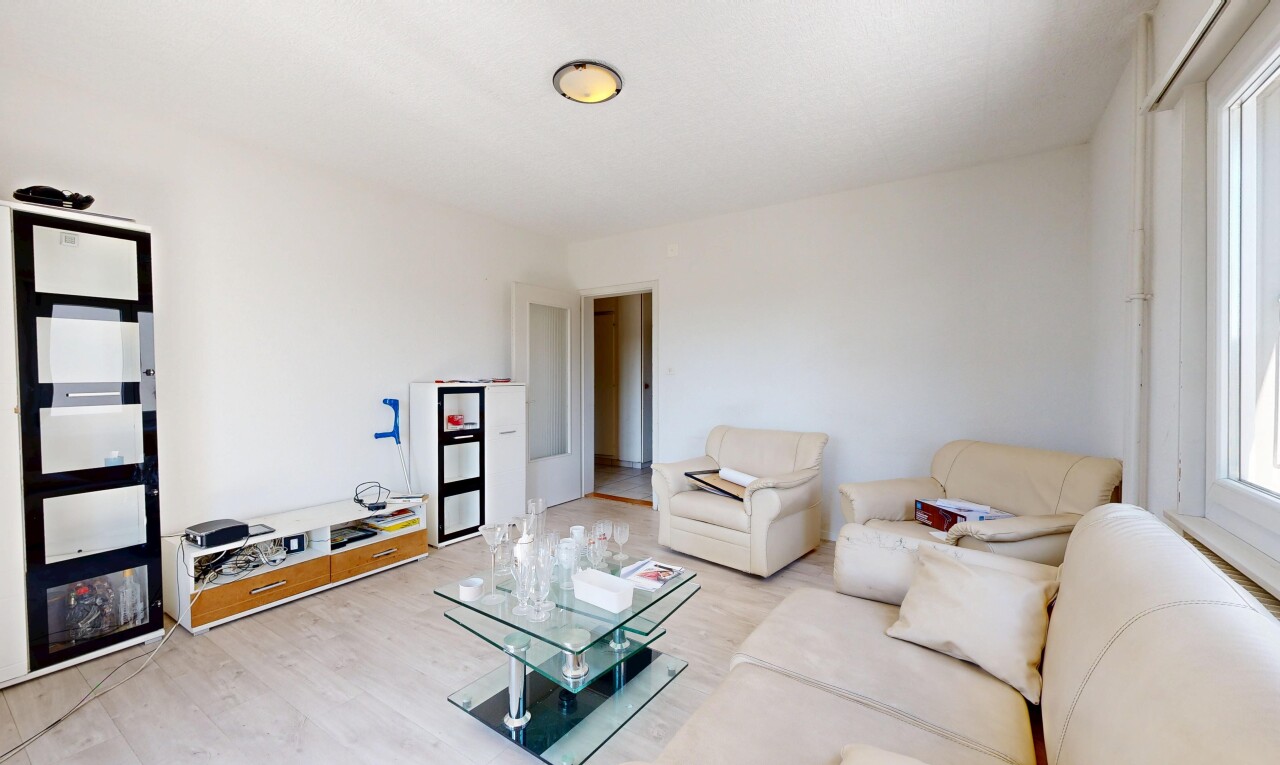 salon avec inside property, cloison sèche, drywall, sol en finition bois, et wood finish floor