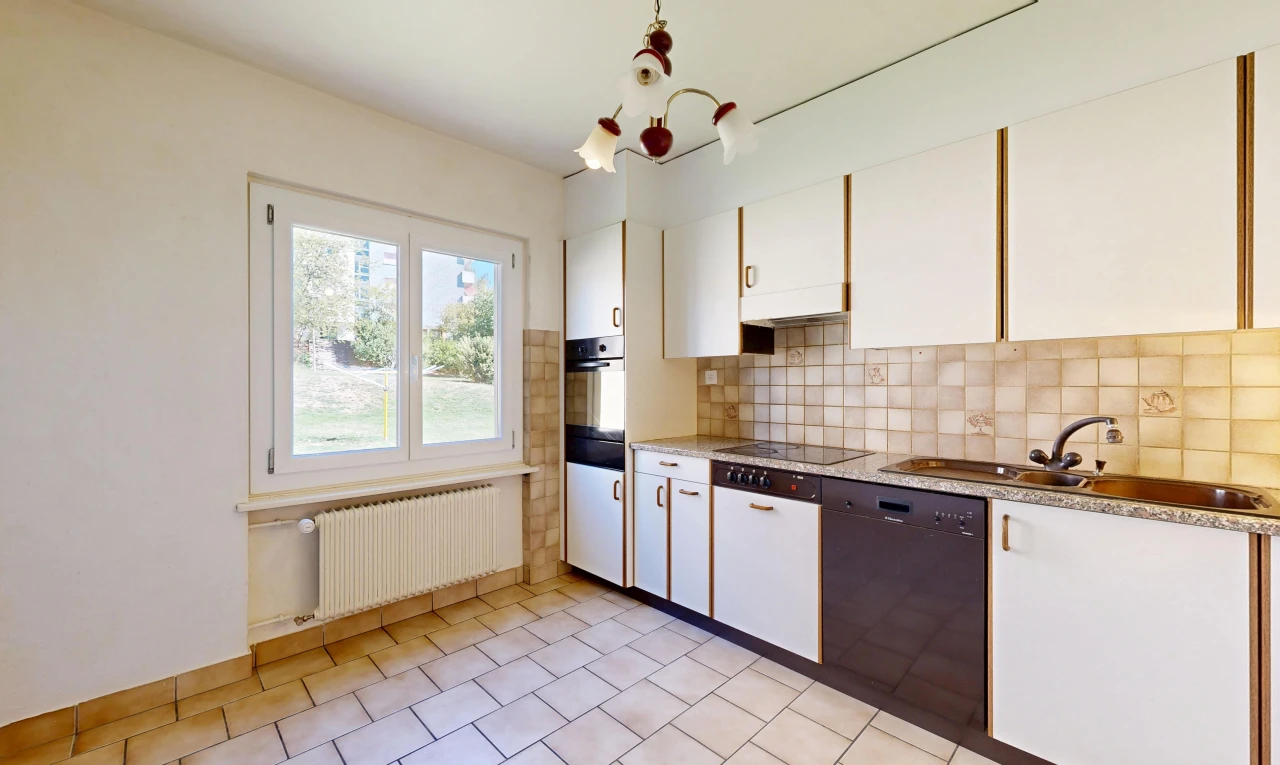 cuisine avec light floor, radiateur, lave-vaisselle, backsplash, et dosseret