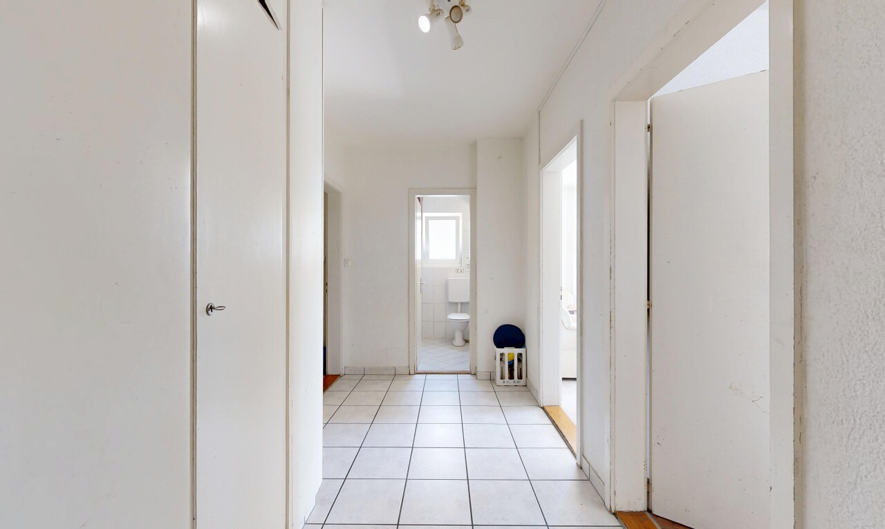 couloir avec inside property, light floor, cloison sèche, drywall, et sol en carrelage