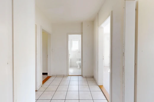 couloir avec light floor, tile floor, sol en carrelage, drywall, et cloison sèche