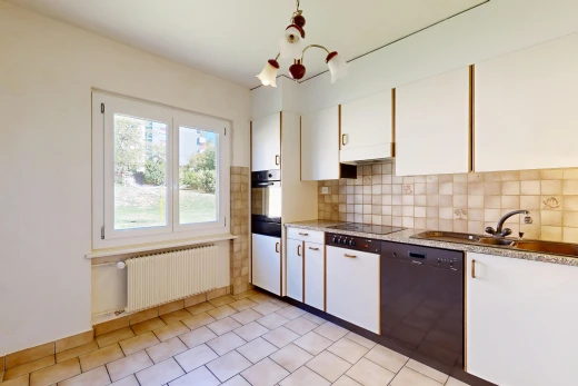 cuisine avec light floor, radiateur, lave-vaisselle, backsplash, et dosseret