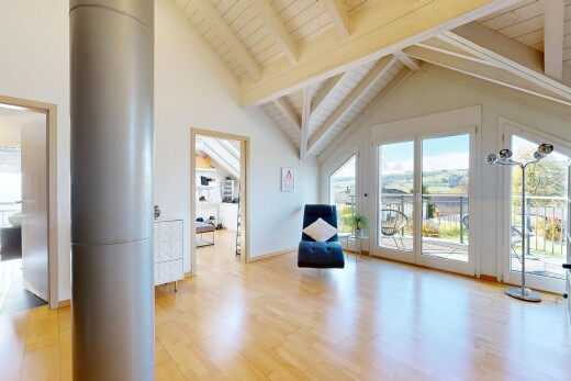 pièce vide avec beamed ceiling, plafond à poutres, wood finish floor, sol en finition bois, et vaulted ceiling