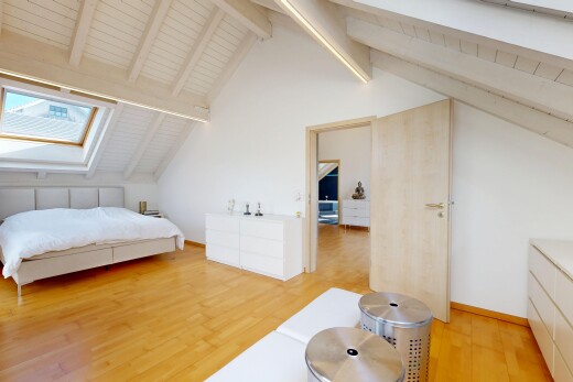 chambre avec beamed ceiling, plafond à poutres, puits de lumière, wood finish floor, et sol en finition bois