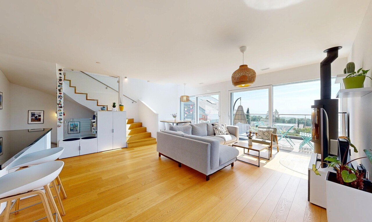salon avec escaliers, sol en finition bois, wood finish floor, lumière naturelle, et natural light