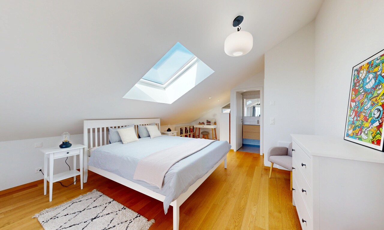 chambre avec light floor, plafond voûté, vaulted ceiling, sol en finition bois, et wood finish floor
