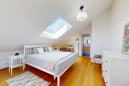 chambre avec light floor, plafond voûté, vaulted ceiling, sol en finition bois, et wood finish floor