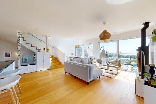 salon avec escaliers, sol en finition bois, wood finish floor, lumière naturelle, et natural light