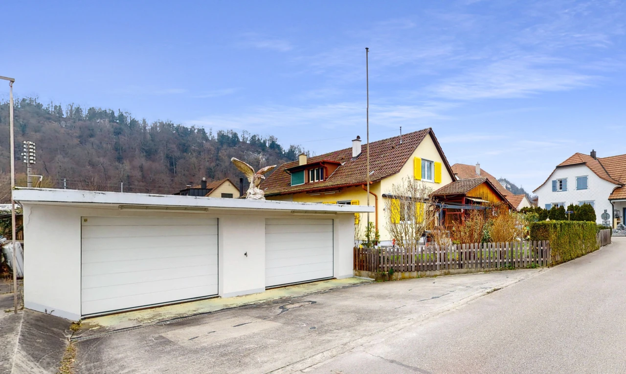 façade avec clôture, structure extérieure, et garage détaché