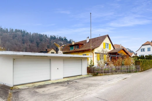 façade avec clôture, structure extérieure, et garage détaché