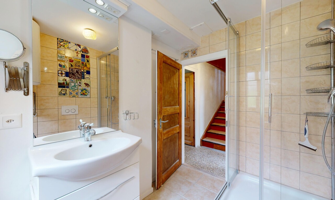 salle de bains avec miroir, douche, salle de bain complète, lavabo (ou coiffeuse selon le contexte), et inside property
