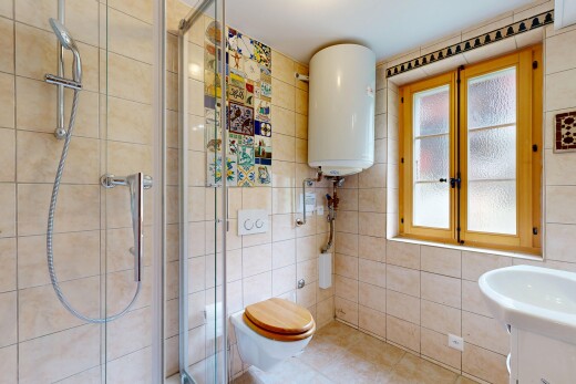 salle de bains avec douche, salle de bain complète, chauffe-eau, lavabo (ou coiffeuse selon le contexte), et mur en carrelage