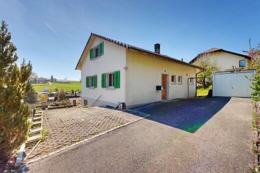 façade avec property visible, bardage en stuc, aire de stationnement, et day time
