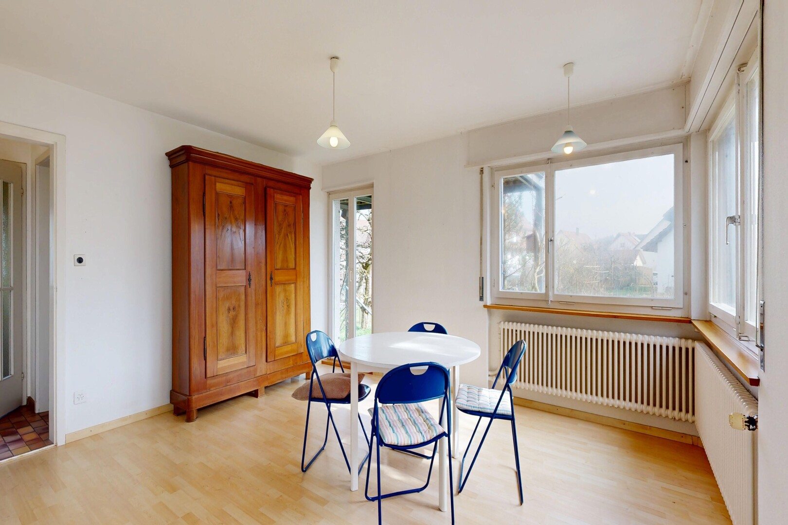 salle à manger avec radiateur, sol en finition bois, wood finish floor, cloison sèche, et drywall