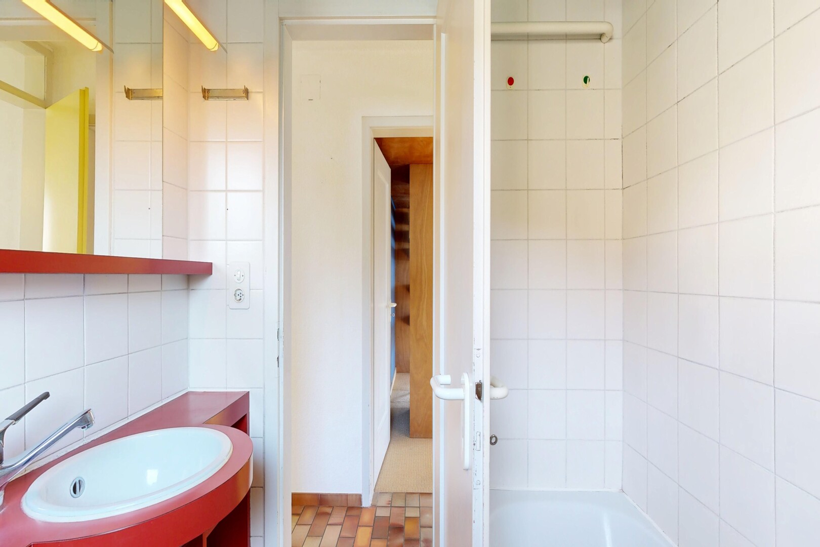 salle de bains avec mur en carrelage, tile wall, miroir, lavabo (ou coiffeuse selon le contexte), et évier