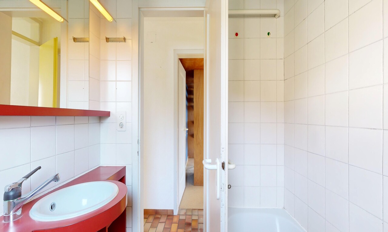 salle de bains avec mur en carrelage, tile wall, miroir, lavabo (ou coiffeuse selon le contexte), et évier