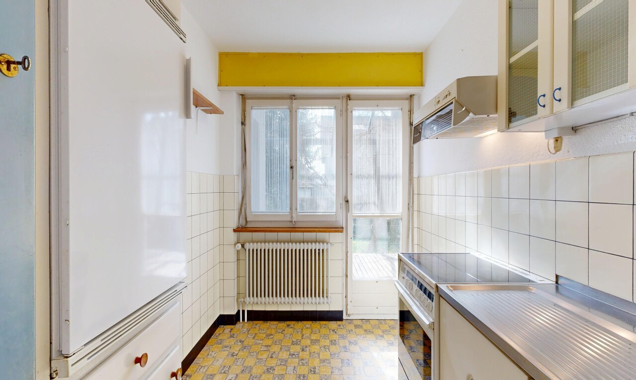 cuisine avec cuisinière, hotte, réfrigérateur, armoires avec insert en verre, et glass insert cabinets