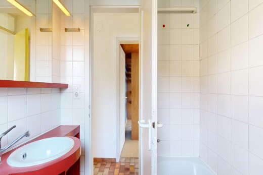 salle de bains avec mur en carrelage, tile wall, miroir, lavabo (ou coiffeuse selon le contexte), et évier