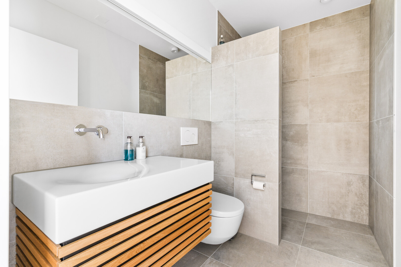 bathroom featuring tile walls, vanity, light tile patterned flooring, and walk in shower