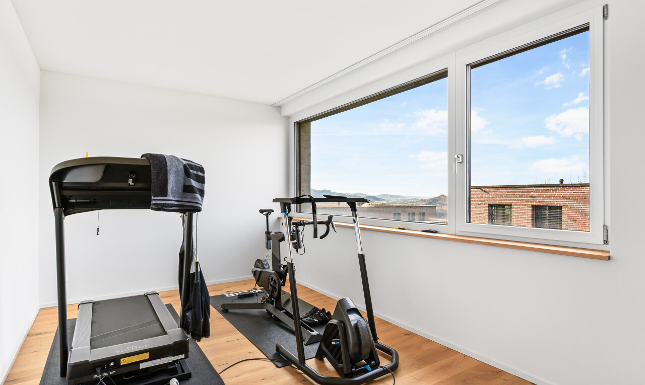 fitnessstudio mit inside property, natural light, natürliches licht, wood finish floor, und holzfußboden