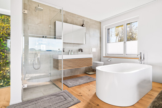 full bath featuring light wood-type flooring, a stall shower, a freestanding bath, and vanity