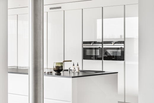 kitchen with white cabinets, stainless steel double oven, dark countertops, and modern cabinets