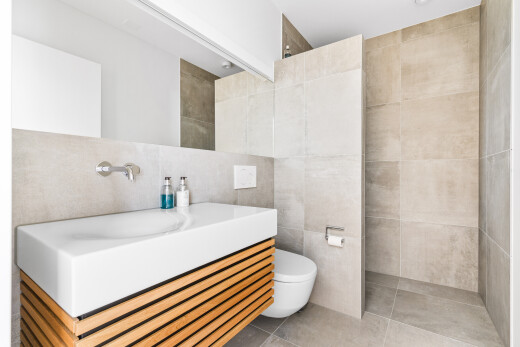 bathroom featuring tile walls, vanity, light tile patterned flooring, and walk in shower