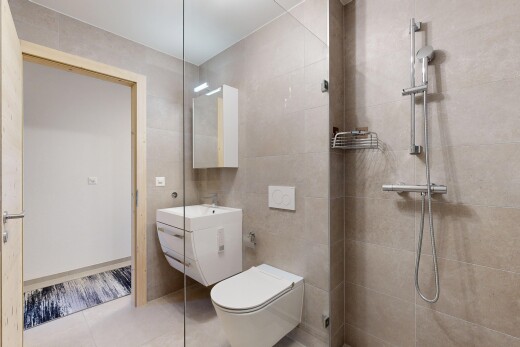 bathroom featuring tile walls, vanity, light tile patterned flooring, and a tile shower