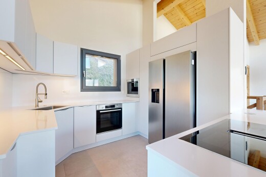 cuisine avec light countertops, flat panel cabinets, armoires à panneau plat, armoires blanches, et natural light